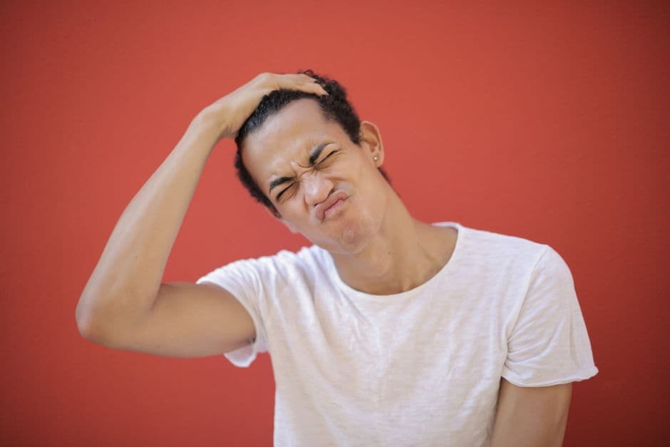 A man scratching the side of his beard