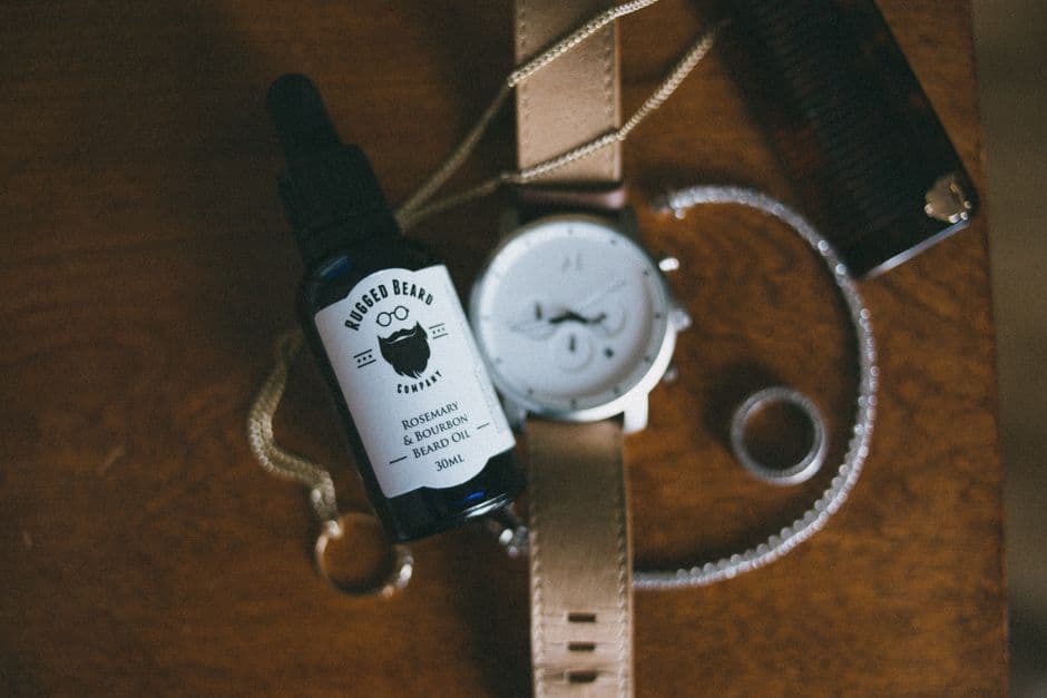 Beard oil and a comb on a bathroom shelf