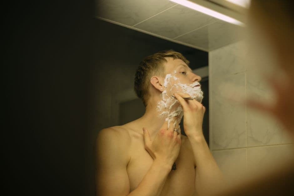 A man shaving off a beard with a razor