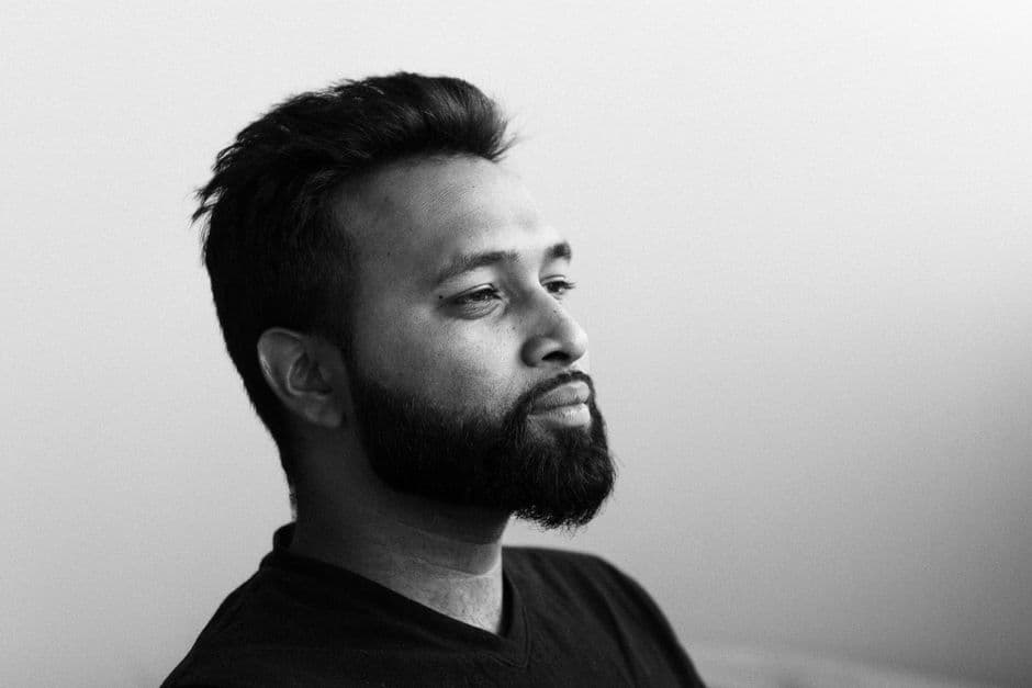 A portrait of a man with a full trimmed beard