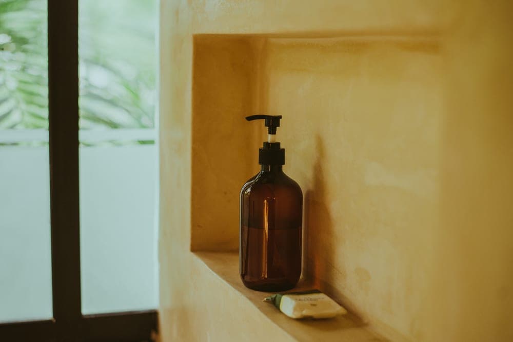 A beard wash bottle on a bathroom shelf