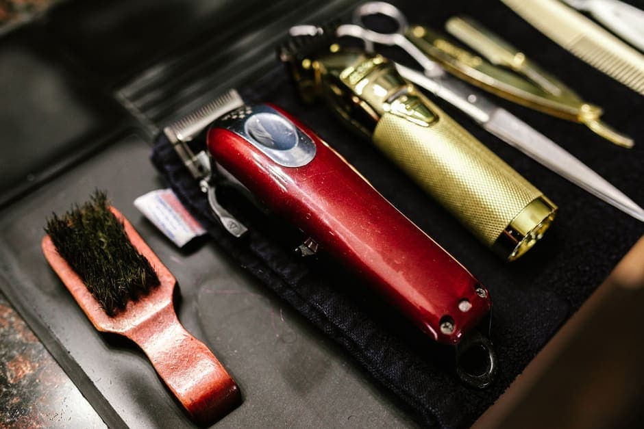 Clippers, a cleaning brush and other grooming tools laid out on a mat