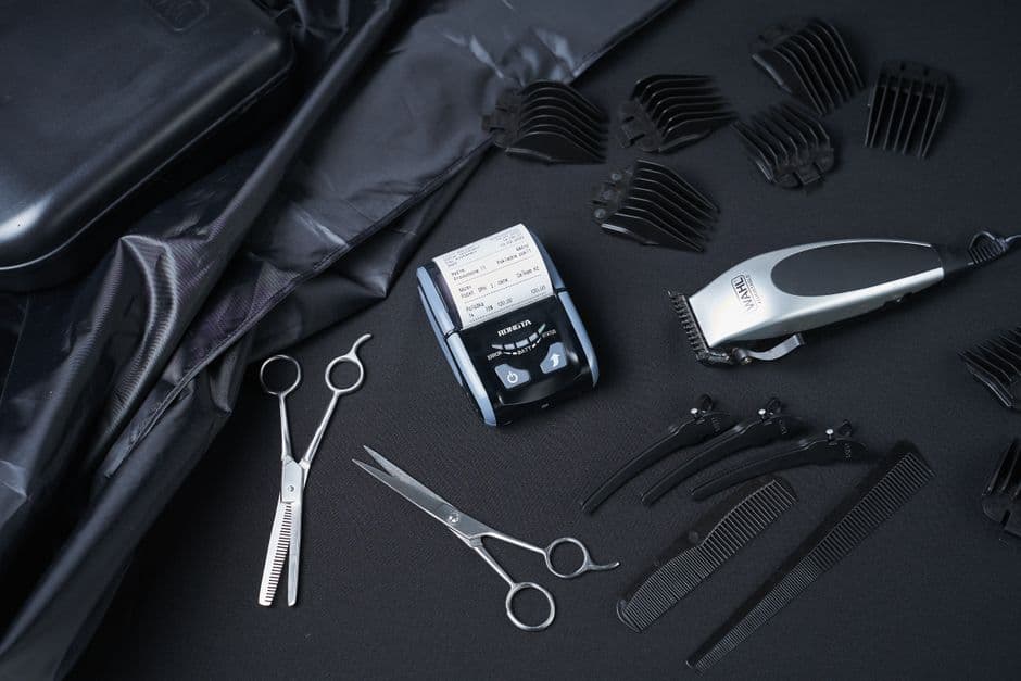 An electric body groomer and a beard trimmer on a surface