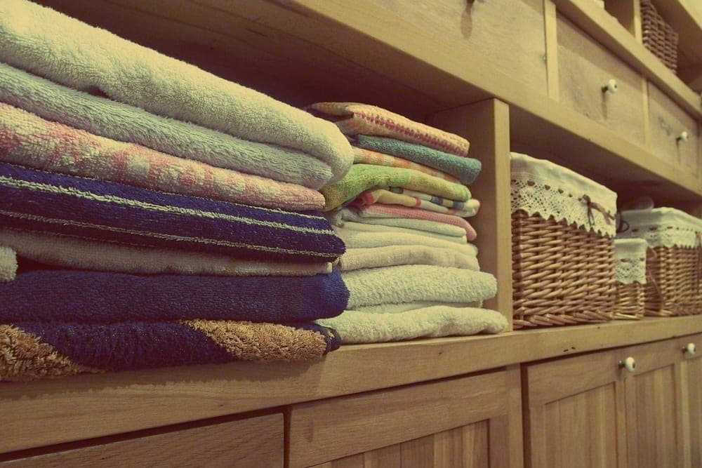 A clean folded shirt and towel on a shelf