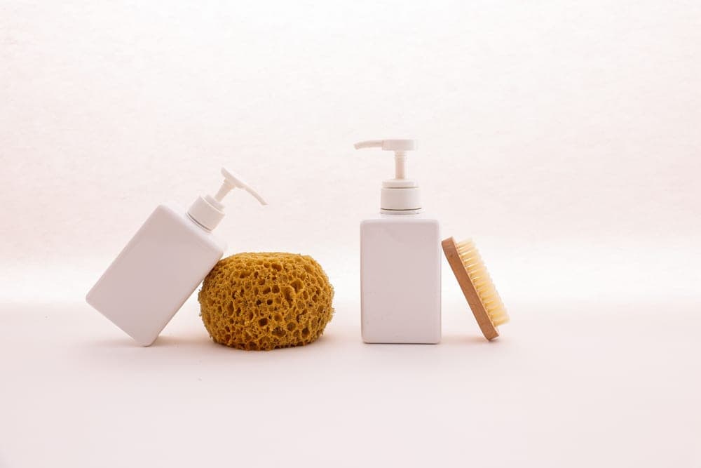 A body wash bottle on a tiled shower ledge
