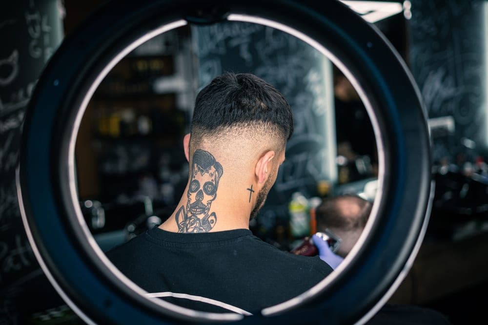 A man using an electric razor along his neck
