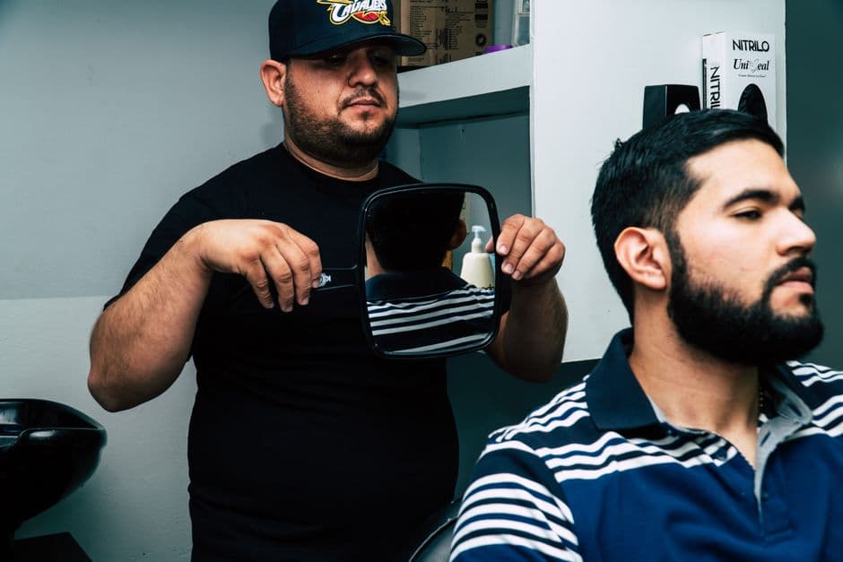 A man examining his haircut in a mirror
