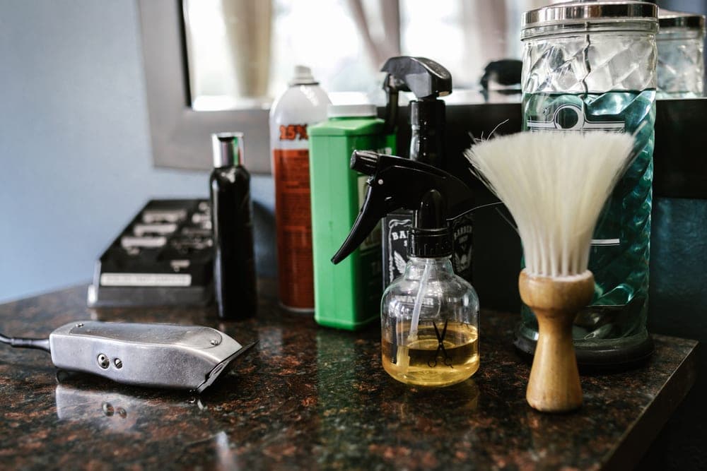 Clipper blades and a small bottle of oil on a work surface