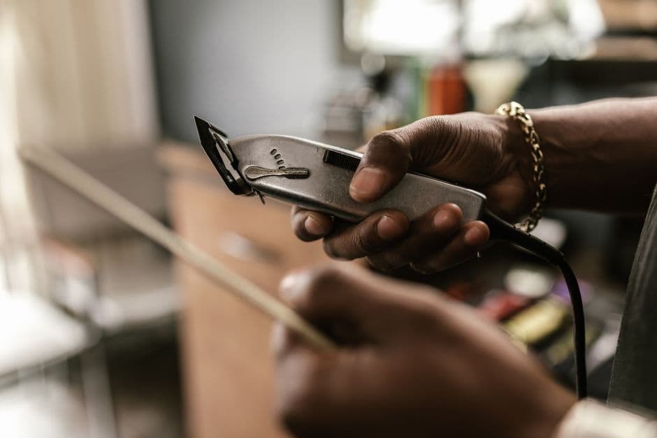 A barber holding clippers in a barbershop