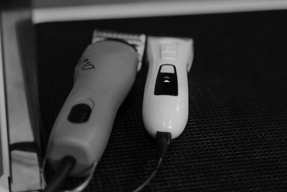 A clipper with its cord coiled beside a cordless clipper