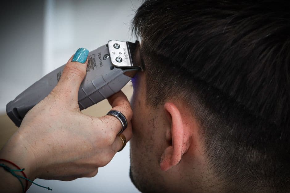 A barber cutting short hair with clippers