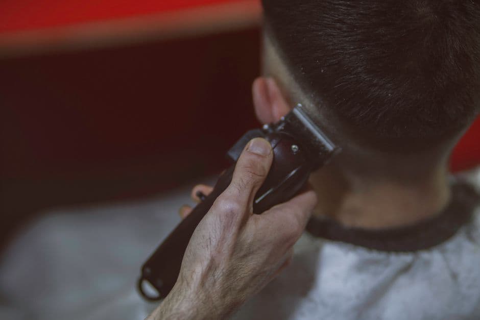A barber fading the side of a client's hair with clippers