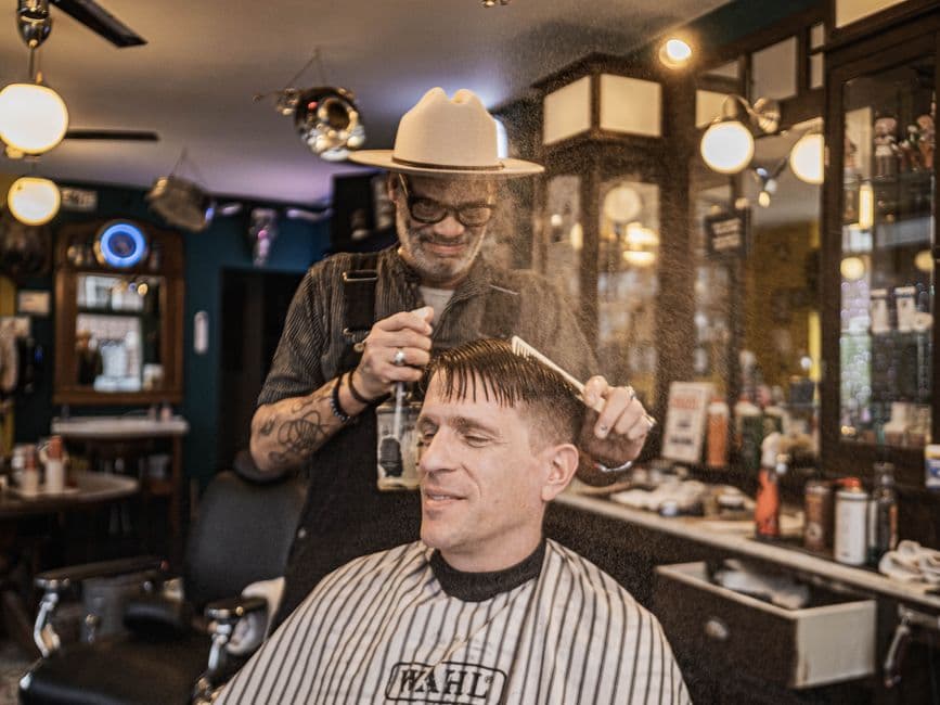 A man styling his hair in front of a mirror