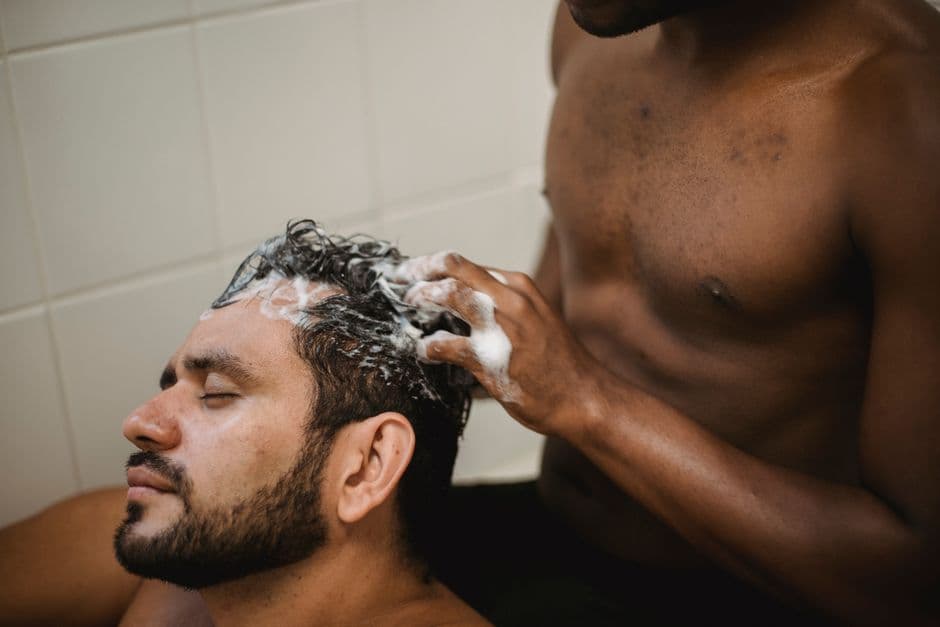 A man washing his hair in the shower