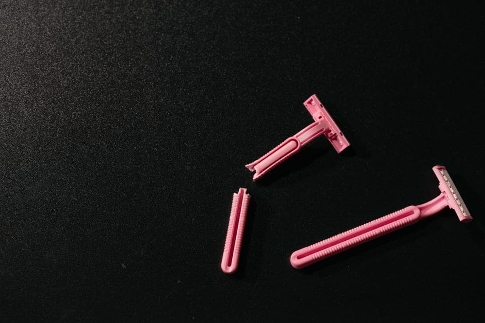 Loose razor blades scattered on a dark surface