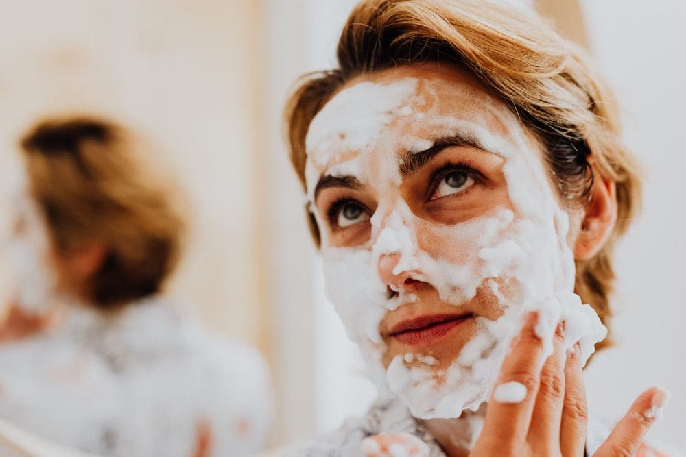 A man washing his face with foaming cleanser