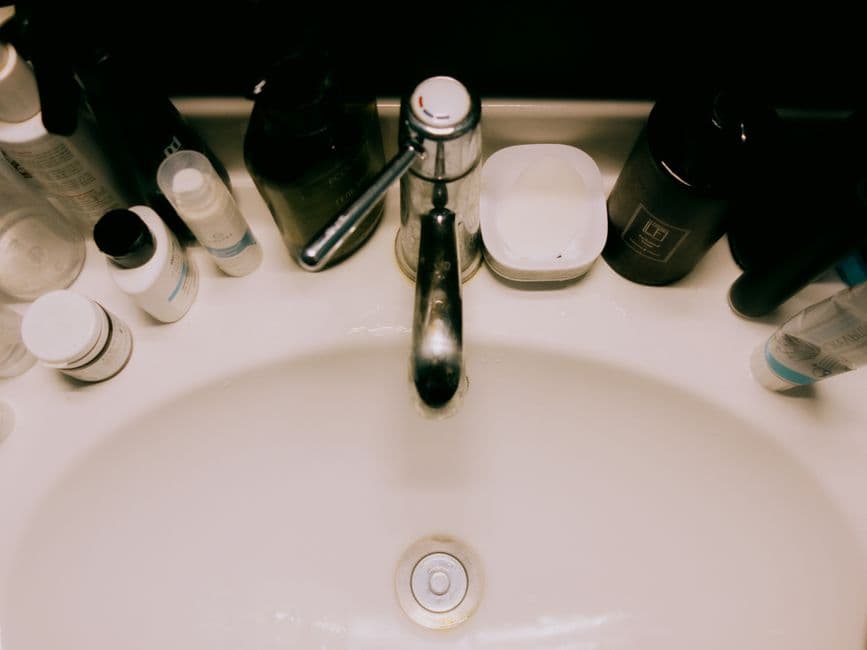 An overhead view of a bathroom sink surrounded by toiletries