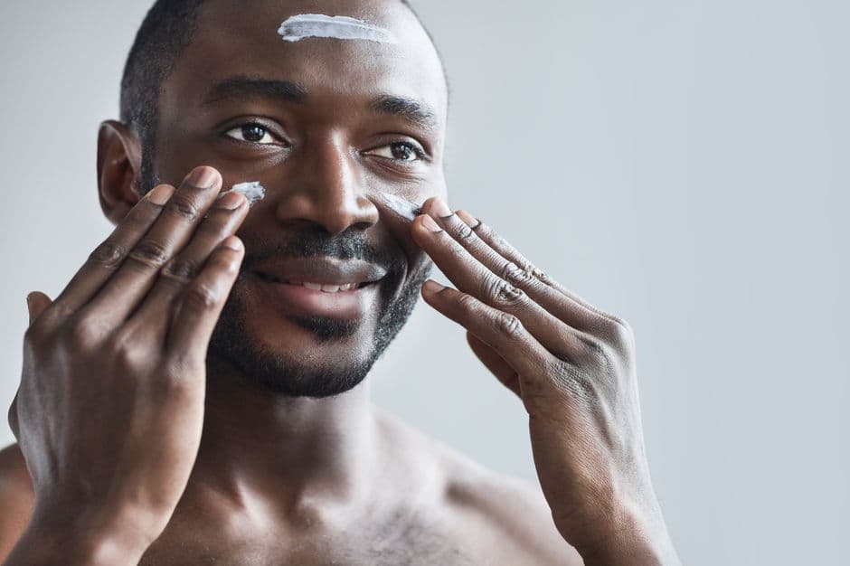 A man applying face cream as part of his skincare routine