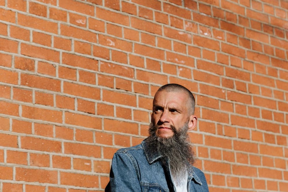 A bearded man outdoors in strong sunlight